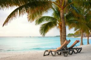 Sun beds under coconut palm trees, Mexico Caribbean coast.